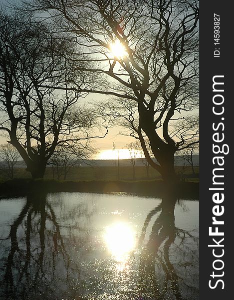 Sunset at a pond in scotland between 2 trees. Sunset at a pond in scotland between 2 trees