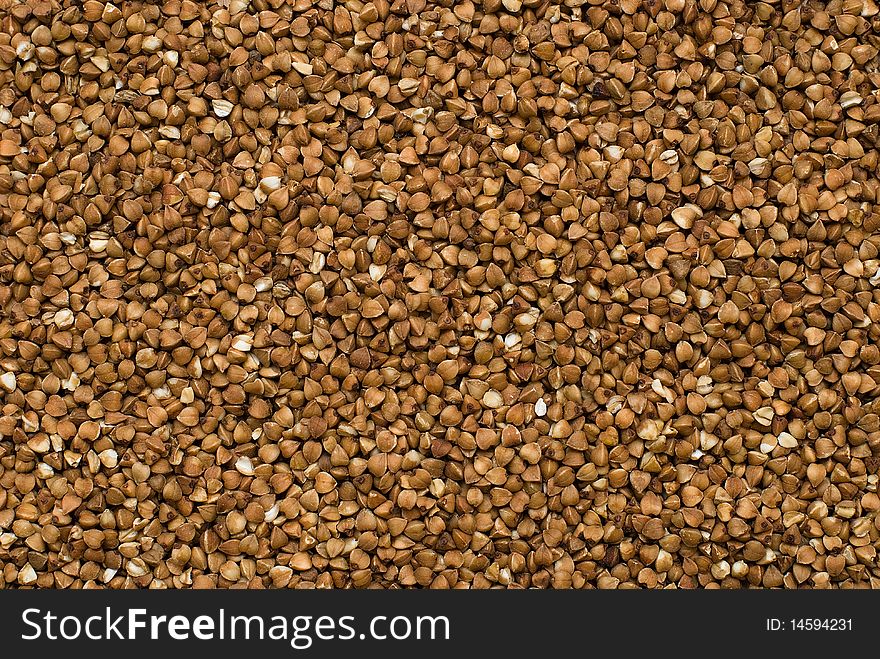 Close-up buckwheat cereal brown background. Close-up buckwheat cereal brown background