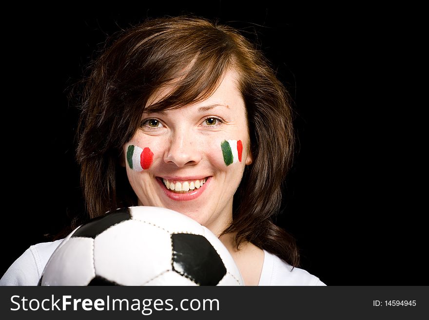 Young happy female with italian flags painted on her cheeks, holds football, soccer ball in front of her, studio isolated shoot on black background. Young happy female with italian flags painted on her cheeks, holds football, soccer ball in front of her, studio isolated shoot on black background