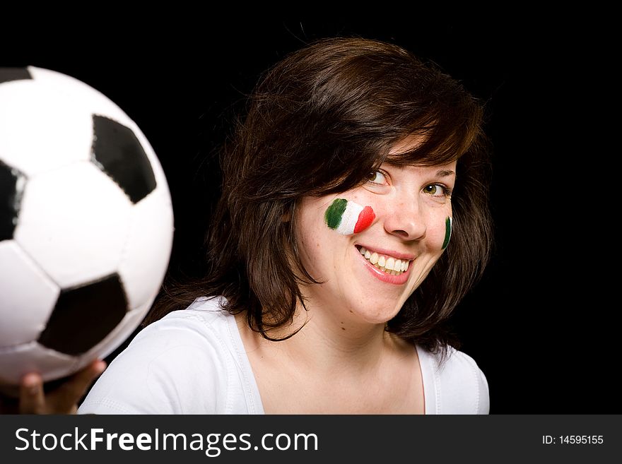 Young happy female with italian flags painted on her cheeks, holds soccer ball in front of her, studio isolated shoot on black background. Young happy female with italian flags painted on her cheeks, holds soccer ball in front of her, studio isolated shoot on black background