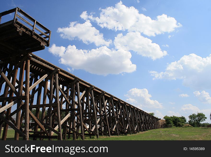 Old wooden railroad and a blue sky with white clouds