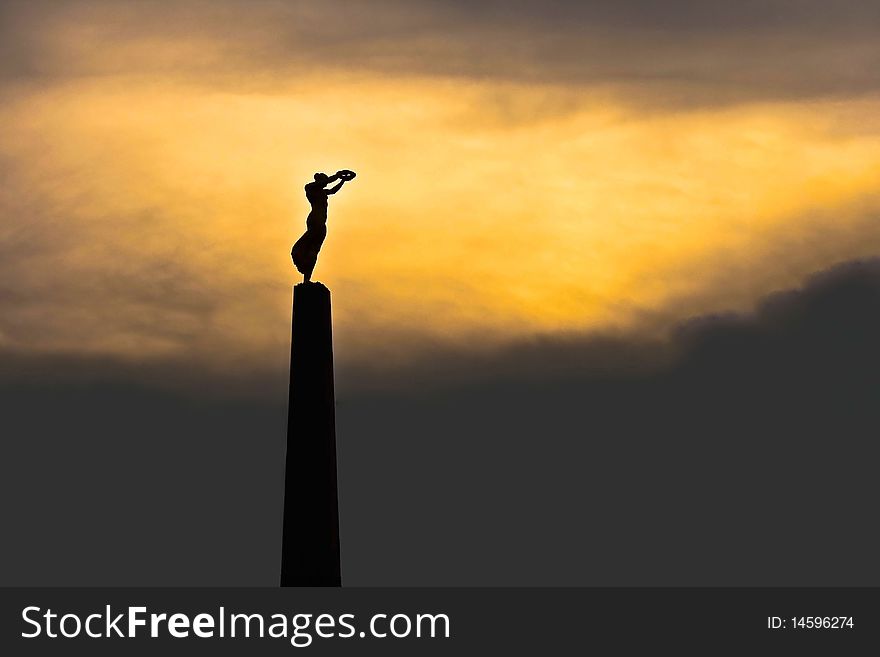 Monument in the Constitution Place in Luxembourg, commemorating the Luxembourgers who died during the First World War. The monument is known as `Gelle Fra` (Golden Lady). The picture was taken at sunset and the resulting dark construction is intentional. Monument in the Constitution Place in Luxembourg, commemorating the Luxembourgers who died during the First World War. The monument is known as `Gelle Fra` (Golden Lady). The picture was taken at sunset and the resulting dark construction is intentional.