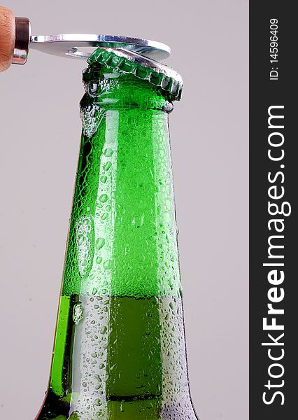 Green beer bottle being opened