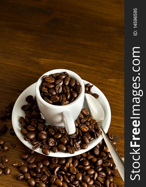 Closeup of a white espresso cup with coffee beans inside