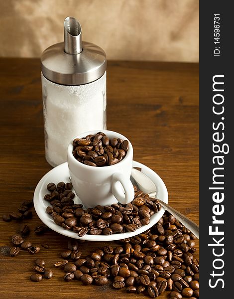 Closeup of a white espresso cup with coffee beans inside