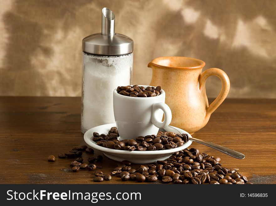 Closeup of a white espresso cup with coffee beans inside