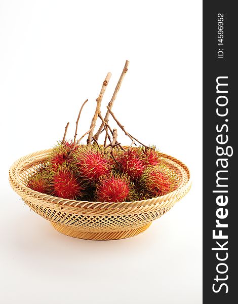 Red rambutan fruits are in a bamboo basket. Red rambutan fruits are in a bamboo basket.