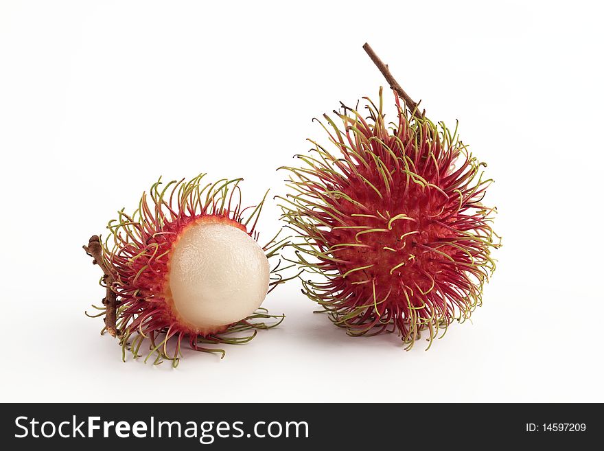 Red hairy rambutan stand on white background. One is half peeled off. Red hairy rambutan stand on white background. One is half peeled off.