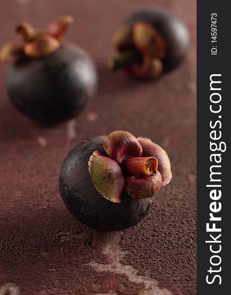 Mangosteens fruit are on a rough background. Mangosteens fruit are on a rough background.