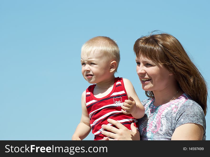 Mum with the small son on hands on a background of the dark blue sky. Mum with the small son on hands on a background of the dark blue sky