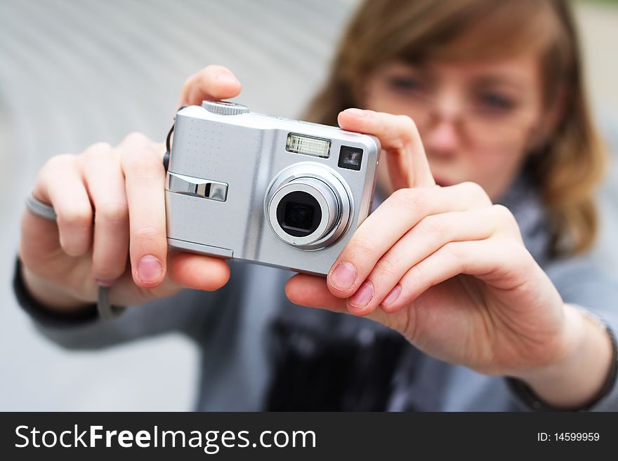 The girl holds the camera in hands. Lifestyle