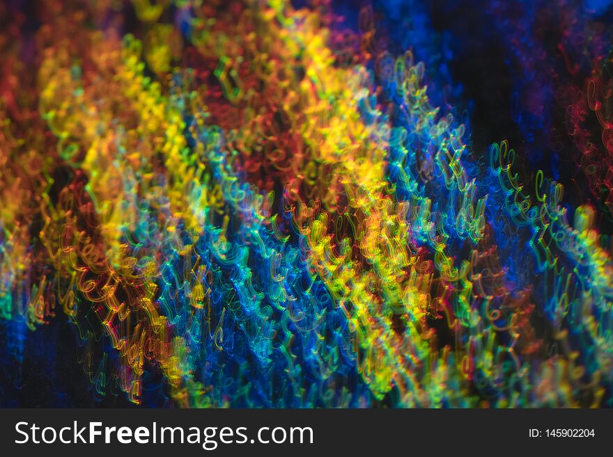 Defocused lights in motion. Swirled thin multicolor lines on dark background. Lens flare effect. Defocused lights in motion. Swirled thin multicolor lines on dark background. Lens flare effect.