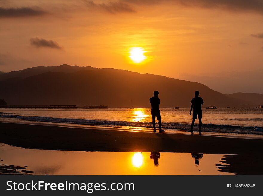 Silhouettes Of People On The Background Of A Golden Dawn On The