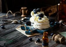 Two Homemade White Mini Desserts Pavlova On Wooden Blue Board With Whipped Cream And Blueberries, Blackberries On Rustic Table Stock Photo