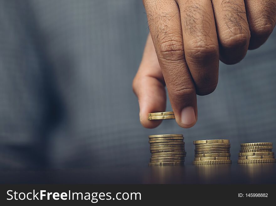 Saving money. businessman hand putting stack coins