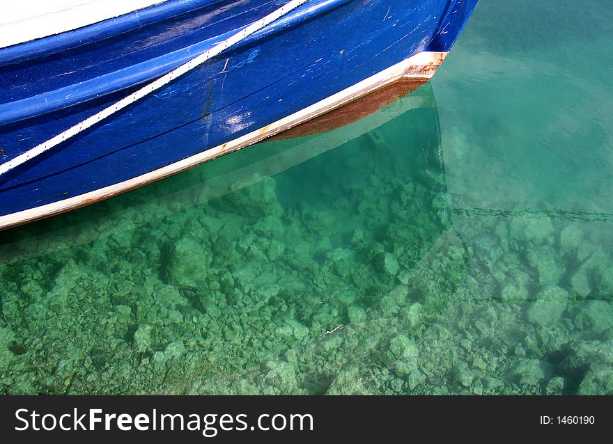 Boat riding at anchor, detail, bow in clear sea-water. Boat riding at anchor, detail, bow in clear sea-water