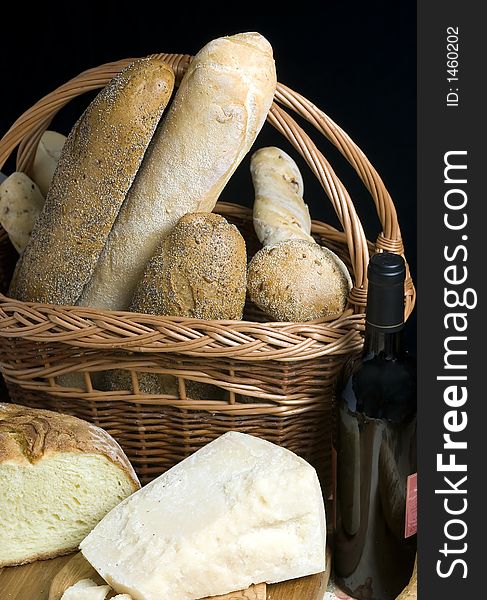 An assortment of hard cheeses and breads with wine. An assortment of hard cheeses and breads with wine