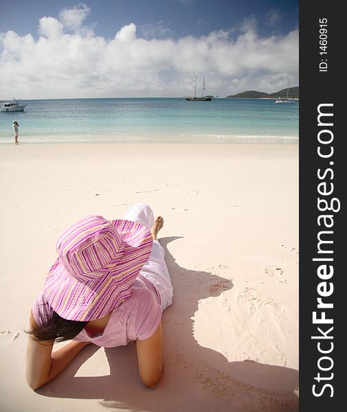 A woman relaxing on the beach at Whitsunday island, Australia. A woman relaxing on the beach at Whitsunday island, Australia