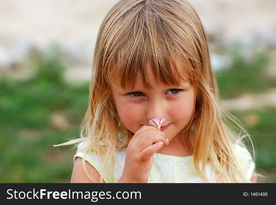 Girl in a garden smelling flower