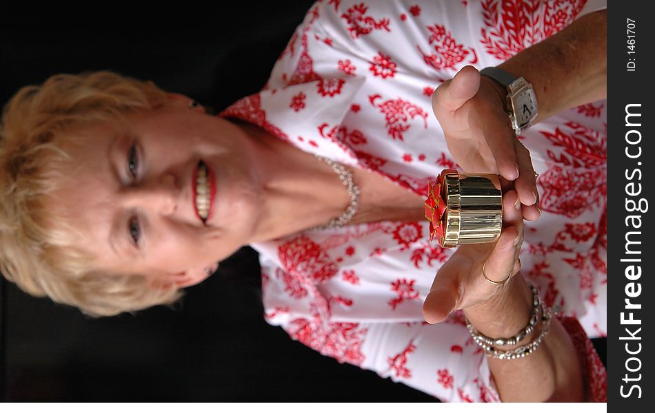 A senior woman holding a christmas gift looking at camera(focus on gift). A senior woman holding a christmas gift looking at camera(focus on gift)