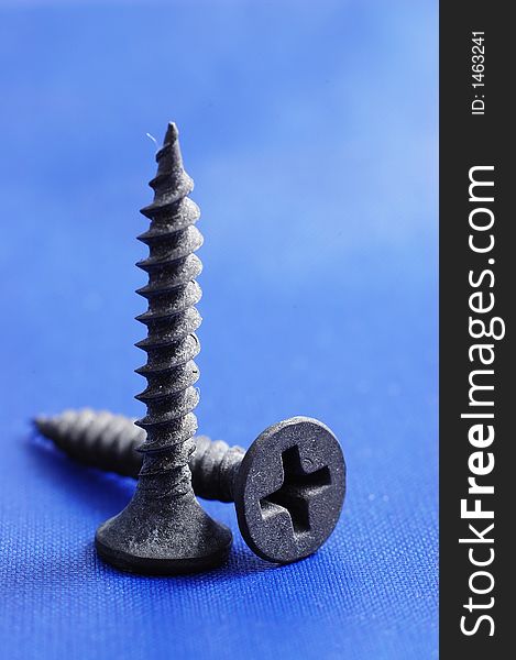 Pair of self-taping screws with blue canvas as background