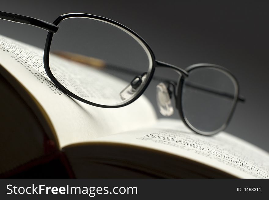 Dark glasses on a book close up