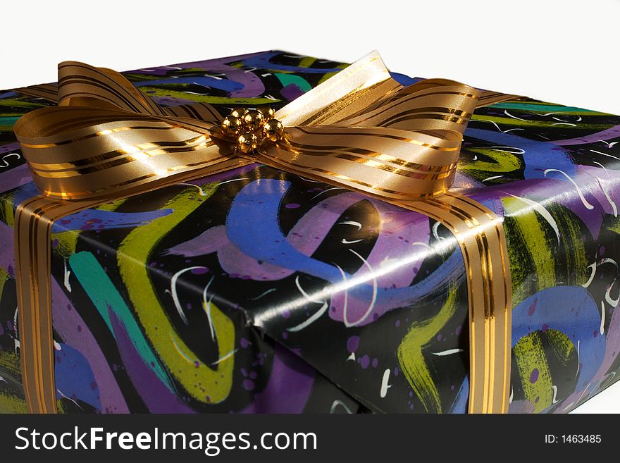 Present wrapped in colourful paper and tied with a golden ribbon. Present wrapped in colourful paper and tied with a golden ribbon