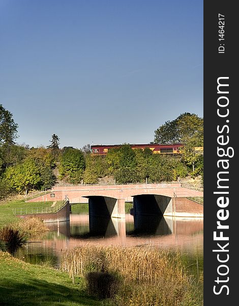 Autumnal scene of a Road Bridge in the foreground and a Railway bridge behind with a locomotive crossing. Autumnal scene of a Road Bridge in the foreground and a Railway bridge behind with a locomotive crossing.