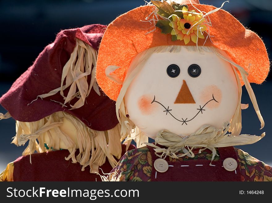 Typical Halloween Decoration - Scarecrow with similing face and red hat.