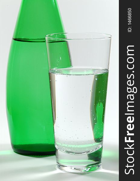 Glass of Mineral Water and Green Bottle. Glass of Mineral Water and Green Bottle
