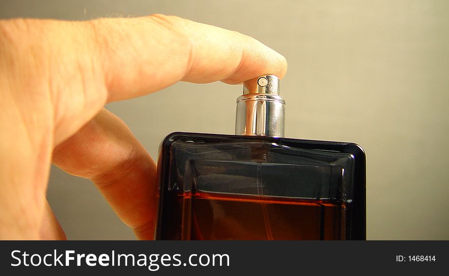 Dark perfume bottle in the hand