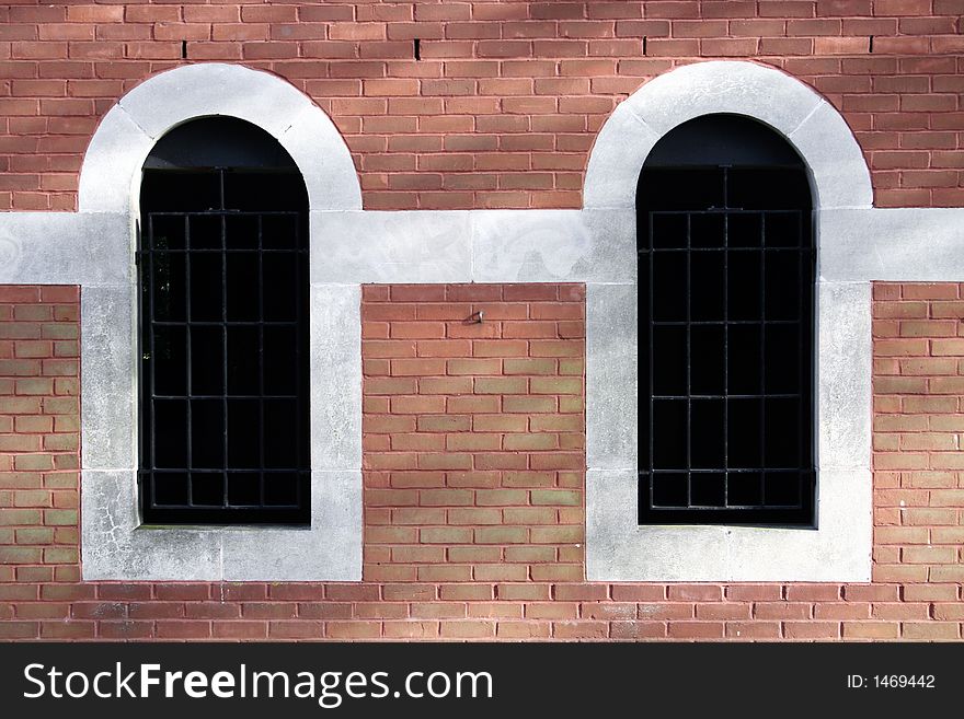 Two arched windows in a brick wall. Two arched windows in a brick wall.