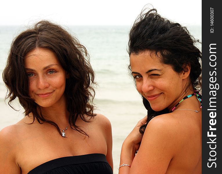 Two beautiful girlfriends on the beach