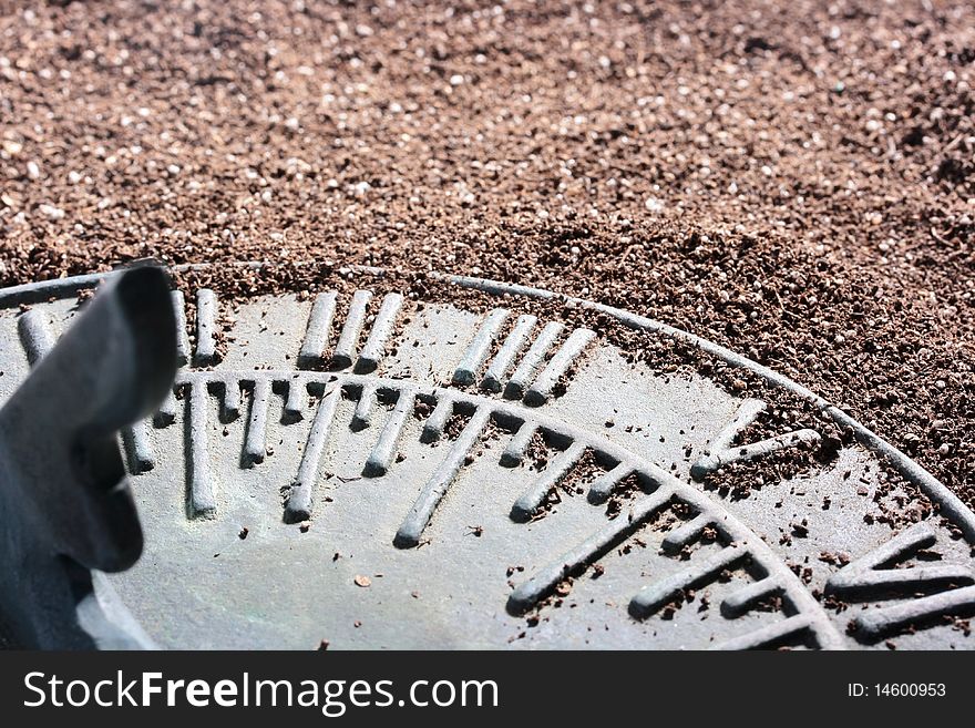 Ancient sundial lies on a dark ground.