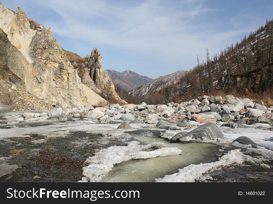 There is spring in the mountains. The spring river sluice in the stone canyon. There is spring in the mountains. The spring river sluice in the stone canyon