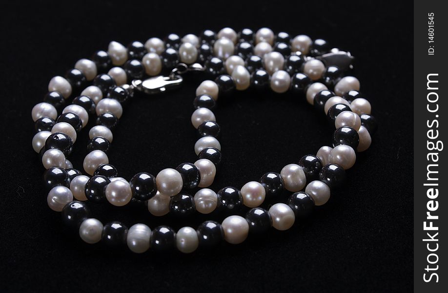 White pearls and black stone beads on a thread. White pearls and black stone beads on a thread
