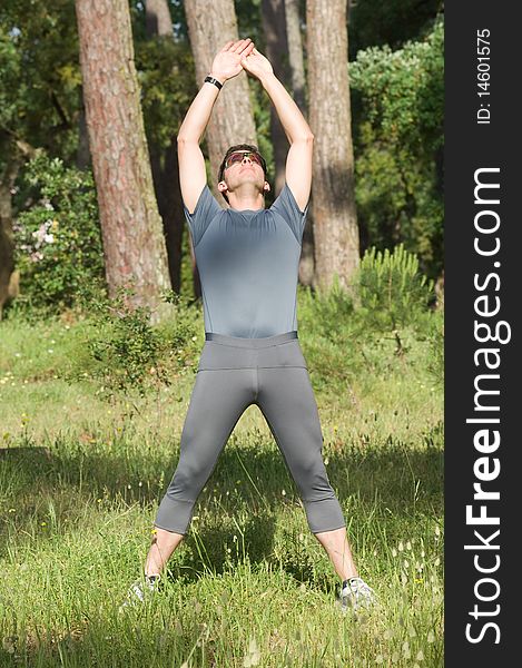 A middle age man making stretching movements before run