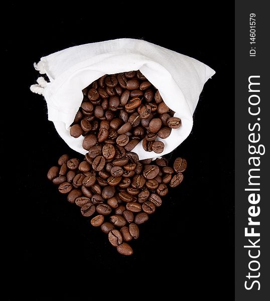 Coffee beans and burlap sack on black background