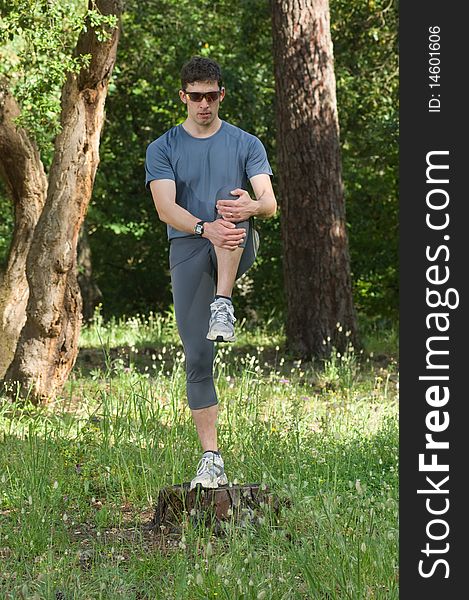 A middle age man making stretching movements before run