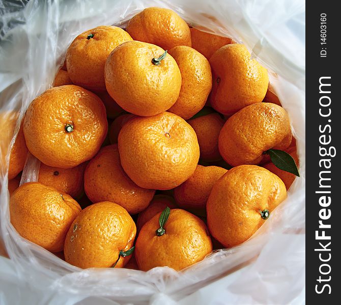 Group of bright oranges lay in in the white bag. Group of bright oranges lay in in the white bag.