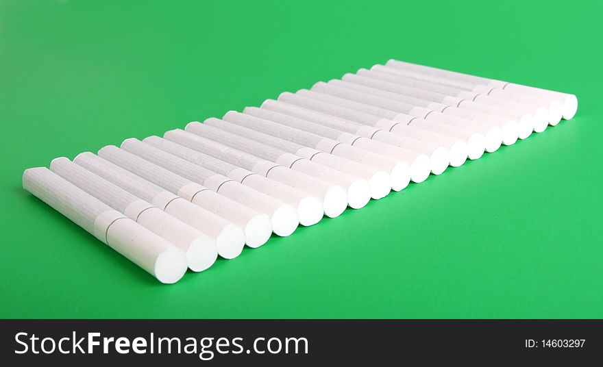 White cigarettes on green background