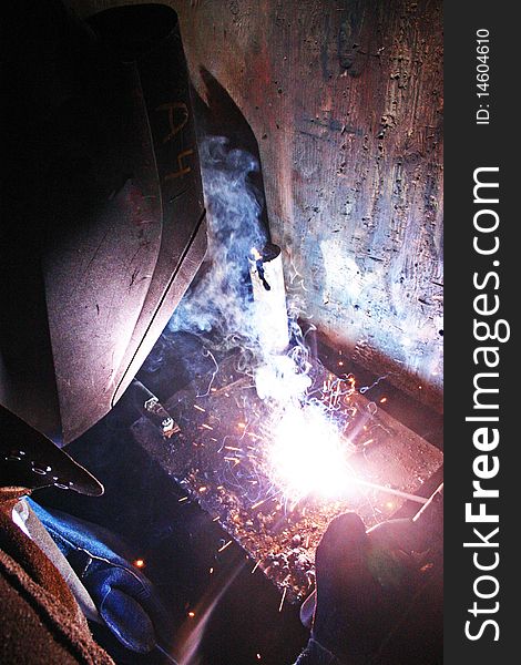 Man sitting and working on a welding project. Man sitting and working on a welding project