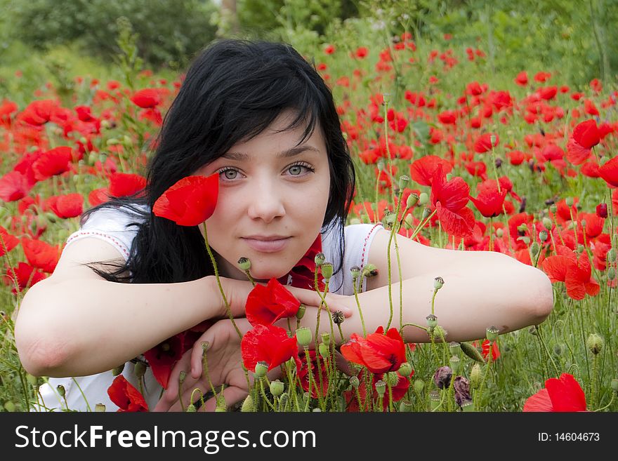 Beautiful Brunette Girl in a Red Poppies field