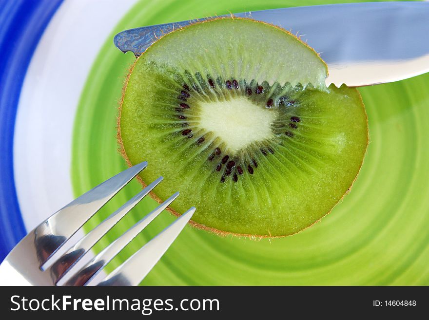 Kiwi, knife and fork on a plate