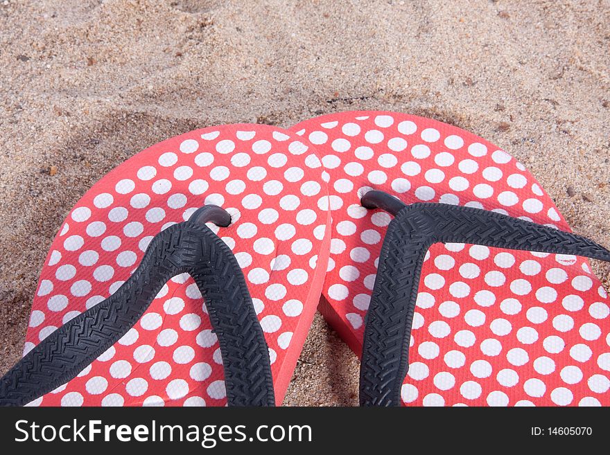 Modern dotted thongs in the sand on the beach