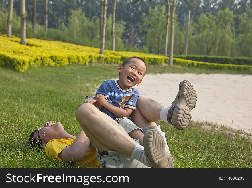 The asian father and his little son are playing with great fun. The asian father and his little son are playing with great fun