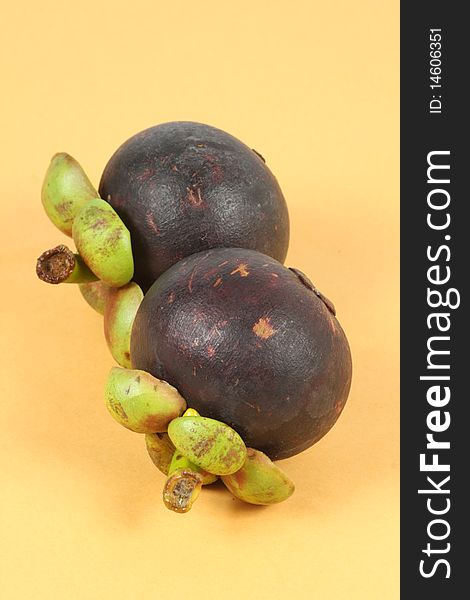 Two Mangosteen on yellow background