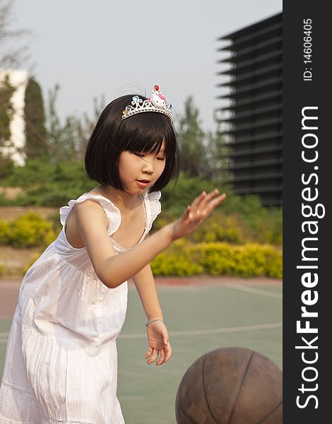 Asian girl bouncing basketball