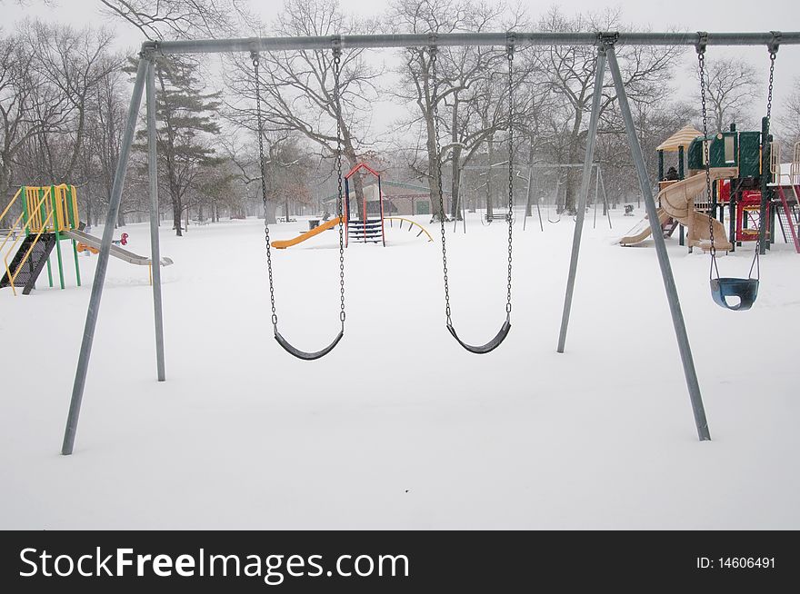 An empty playground in a park, during a winter season.