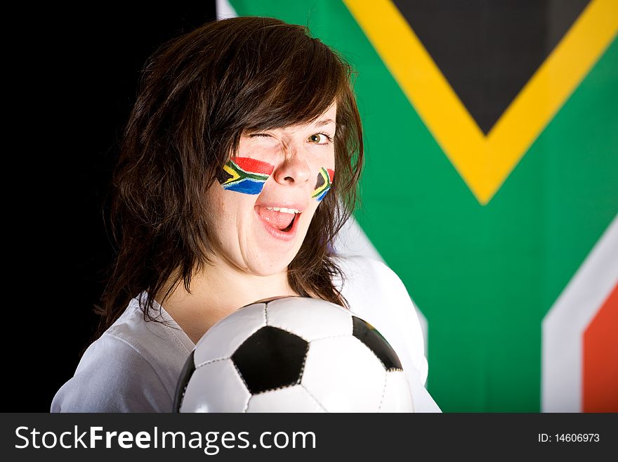 Happy young soccer supporter, flags on her cheeks, holds football ball, south africa flag as background. Happy young soccer supporter, flags on her cheeks, holds football ball, south africa flag as background